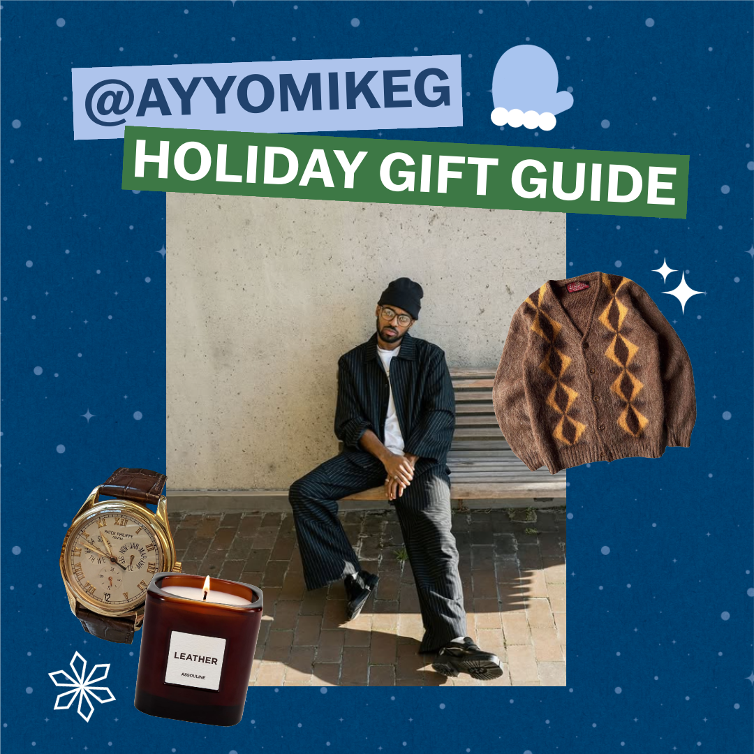 Text reads "@AYYOMIKE G HOLIDAY GIFT GUIDE". The background is blue with sparkles. There is an image of Mike G posing on a chair outdoors. There are cutout images of a watch, a candle, and a brown and orange sweater. There is a snowflake and sparkle surrounding the image.